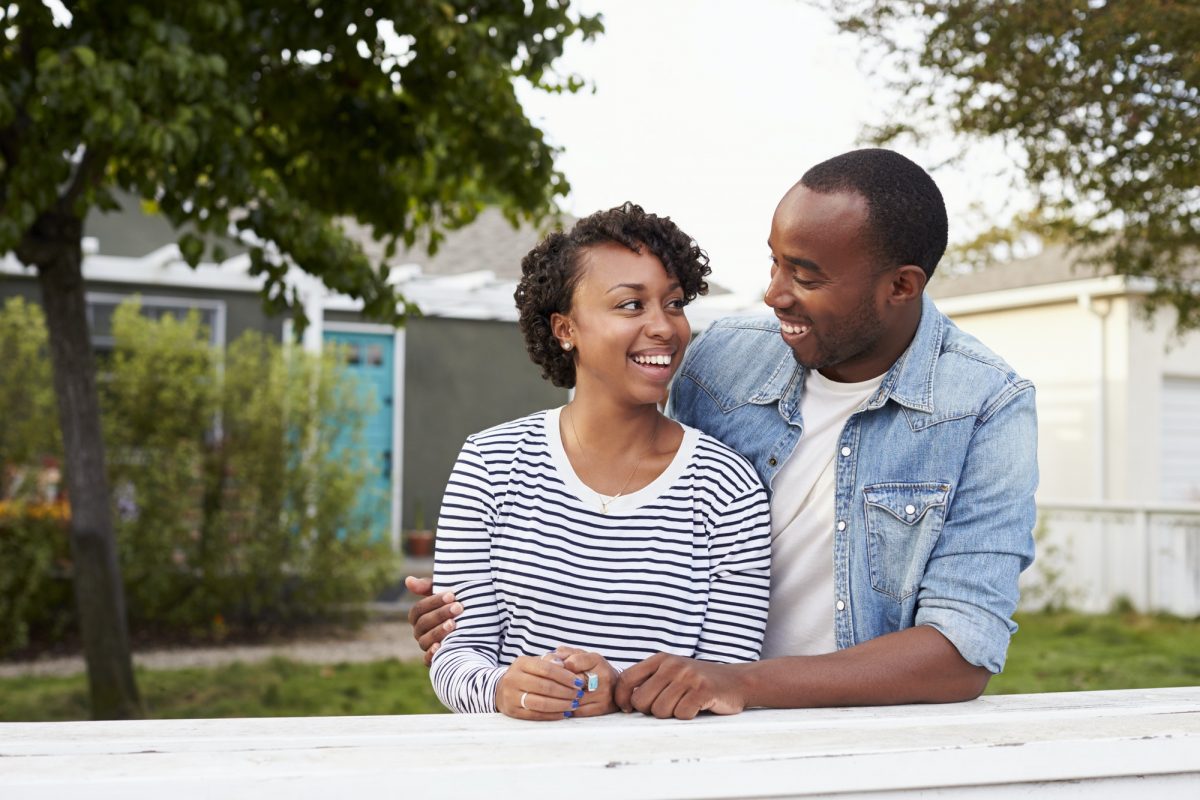 African American couple outside their new house